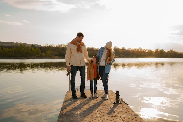 Famiglia a figura intera che va in giro su un molo