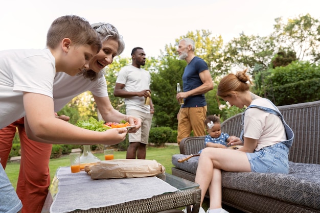 Famiglia a ripresa media con cibo all'aperto