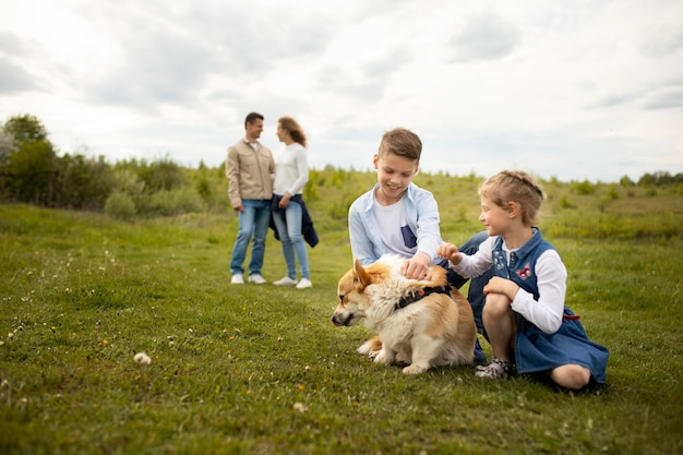 Famiglia a tutto campo che gioca con il cane