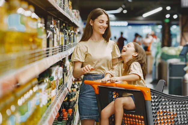 Famiglia al supermercato. Donna in una maglietta marrone. Le persone scelgono i prodotti. Madre con figlia.