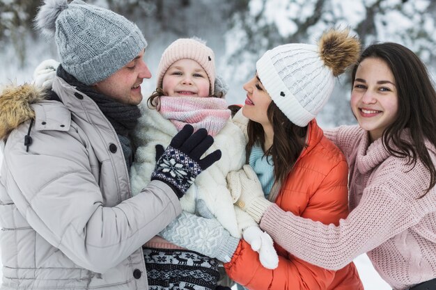 Famiglia allegra che posa in inverno