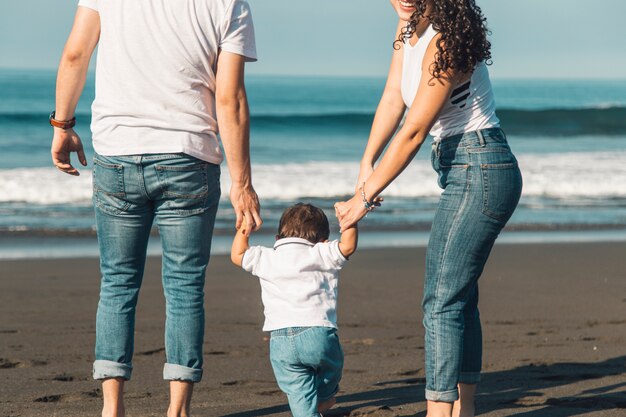 Famiglia andando al mare sulla spiaggia di sabbia