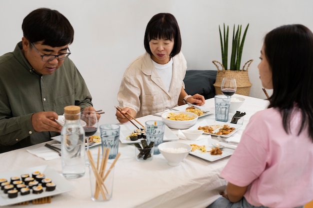 Famiglia asiatica di vista laterale che mangia insieme