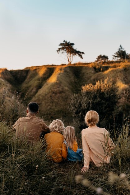 Famiglia carina a tutto campo seduta sull'erba