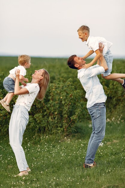 Famiglia carina che gioca in un campo estivo