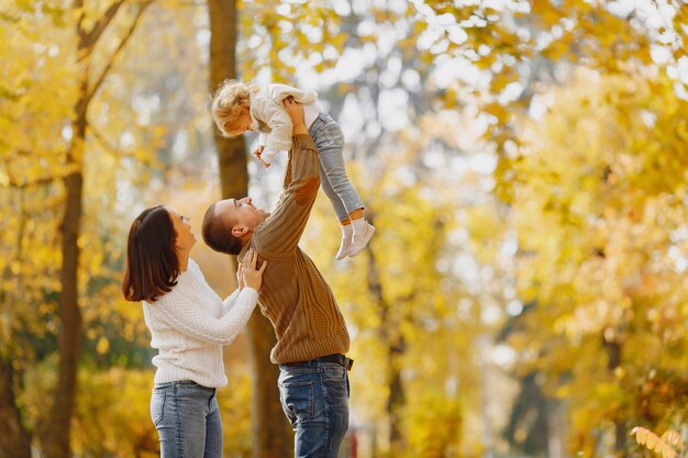 Famiglia carina ed elegante, giocando in un campo autunnale