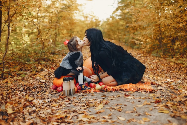 Famiglia carina ed elegante in un parco in autunno