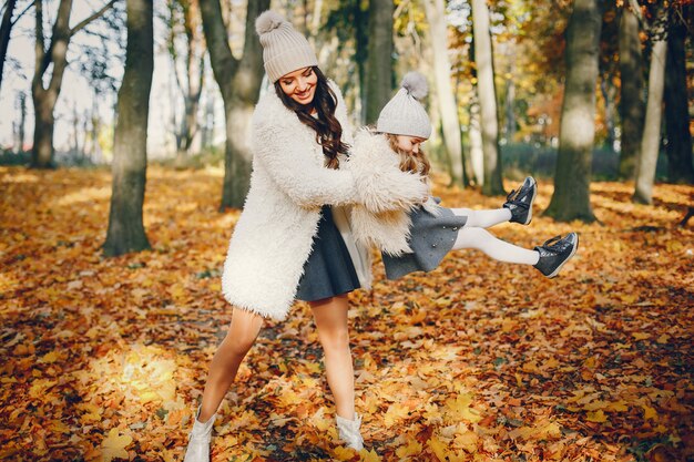 Famiglia carina ed elegante in un parco in autunno