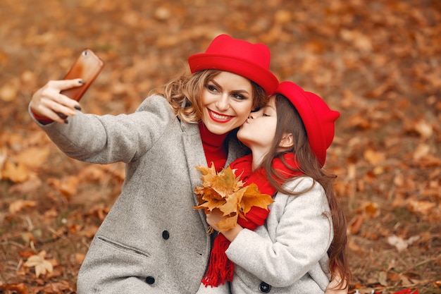 Famiglia carina ed elegante in un parco in autunno