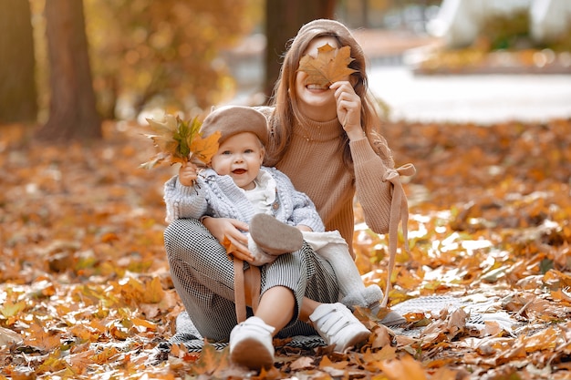 Famiglia carina ed elegante in un parco in autunno