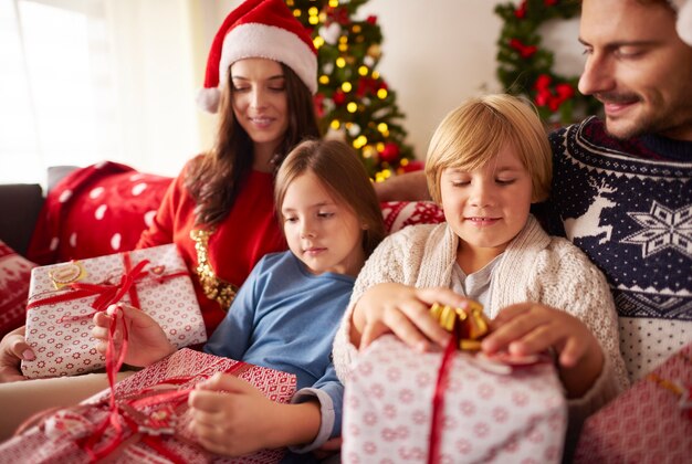 Famiglia che apre i regali di Natale a casa