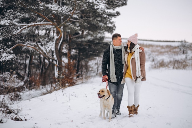 Famiglia che cammina nel parco invernale con il loro cane