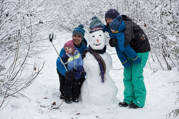 Famiglia che cattura selfie con pupazzo di neve