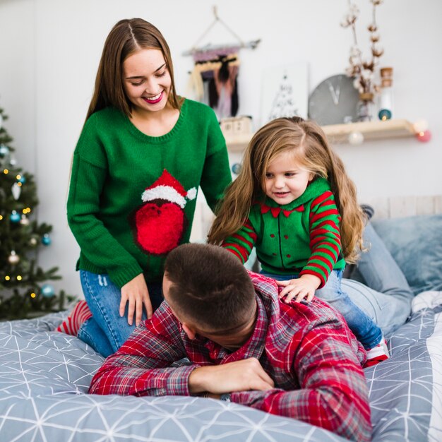 Famiglia che celebra il Natale insieme sul letto