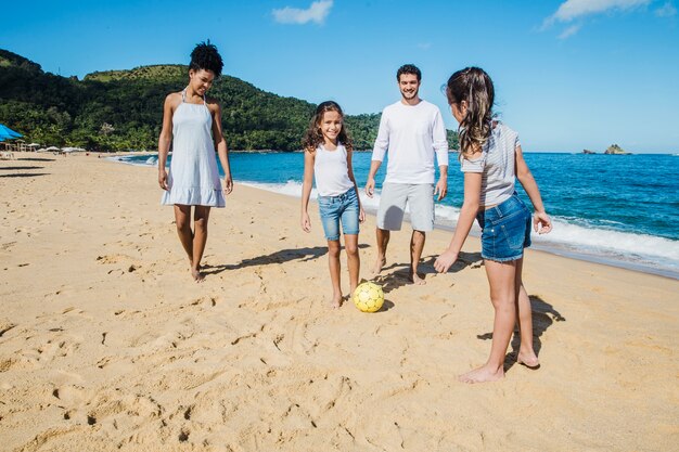 Famiglia che gioca con una palla sulla spiaggia