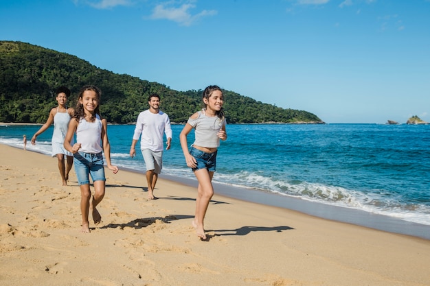 Famiglia che gioca e funziona sulla spiaggia