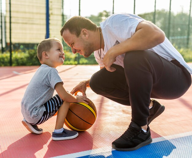 Famiglia che gioca sul campo di basket