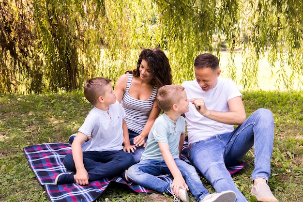 Famiglia che gioca sulla coperta da picnic