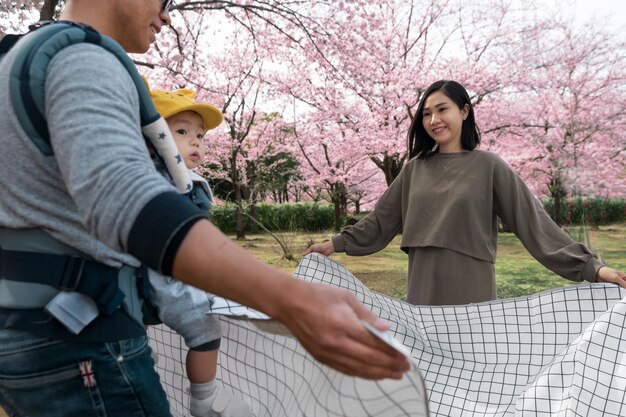 Famiglia che ha un picnic accanto a un albero di ciliegio