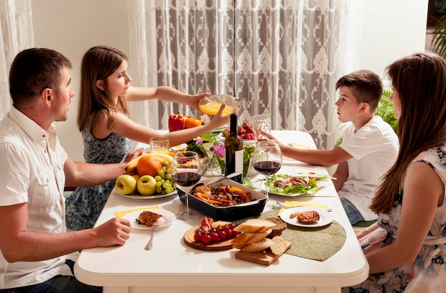 Famiglia che mangia insieme al tavolo da pranzo