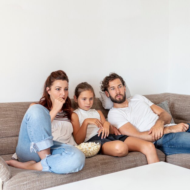 Famiglia che mangia popcorn sul divano