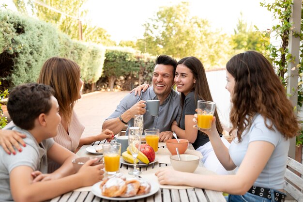 Famiglia che pranza insieme all'aperto