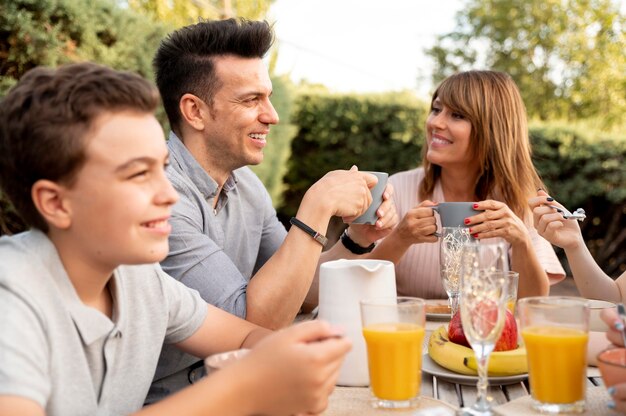 Famiglia che pranza insieme all'aperto