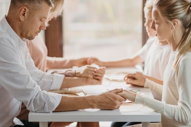 Famiglia che prega prima di mangiare