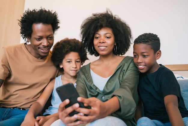 Famiglia che prende selfie insieme al telefono a casa.