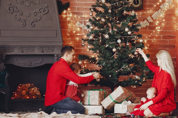 Famiglia che si siede a casa vicino all'albero di Natale