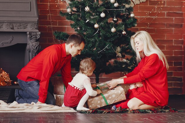 Famiglia che si siede a casa vicino all'albero di Natale