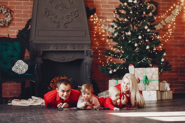 Famiglia che si siede a casa vicino all'albero di Natale