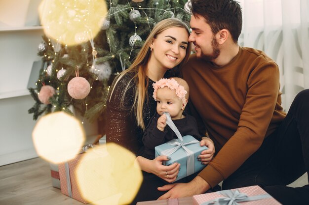 Famiglia che si siede a casa vicino all'albero di Natale