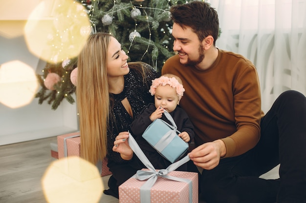 Famiglia che si siede a casa vicino all'albero di Natale