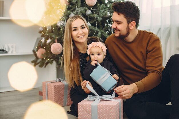 Famiglia che si siede a casa vicino all'albero di Natale