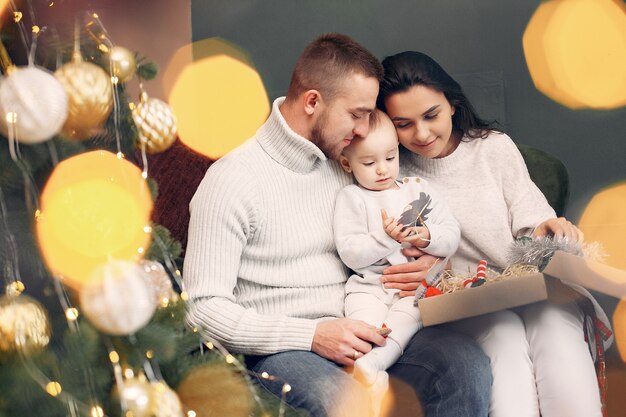 Famiglia che si siede a casa vicino all'albero di Natale