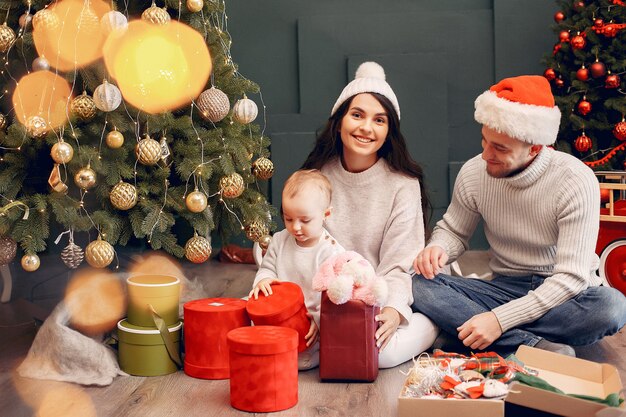 Famiglia che si siede a casa vicino all'albero di Natale