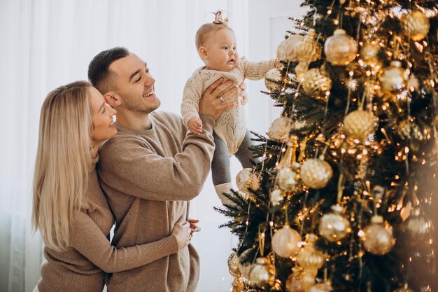 Famiglia con bambina vicino all'albero di Natale