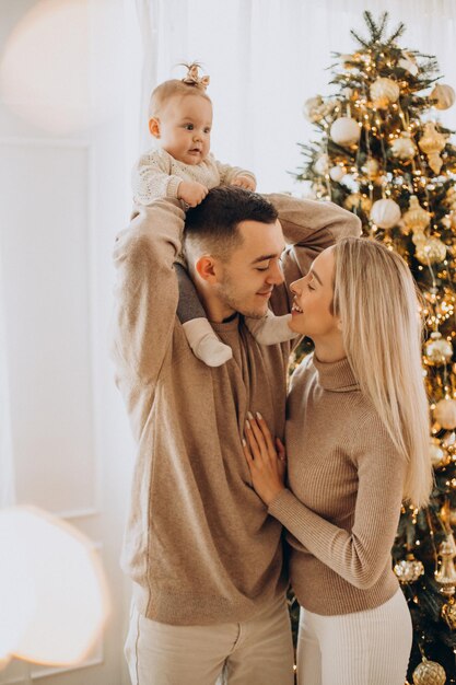 Famiglia con bambina vicino all'albero di Natale