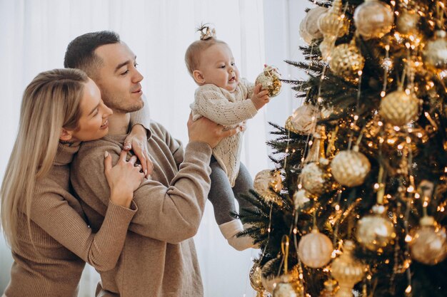 Famiglia con bambina vicino all'albero di Natale