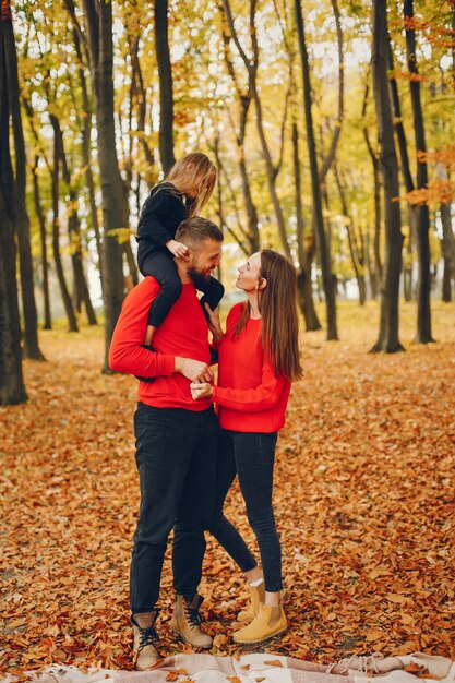 Famiglia con bambini carini in un parco in autunno