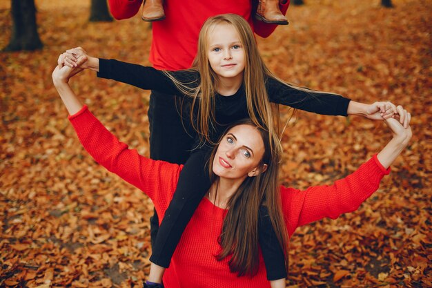 Famiglia con bambini carini in un parco in autunno