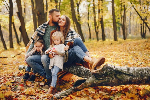 Famiglia con bambini carini in un parco in autunno