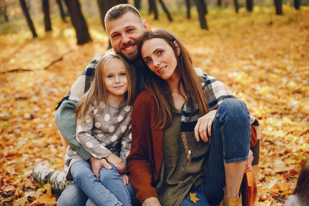 Famiglia con bambini carini in un parco in autunno