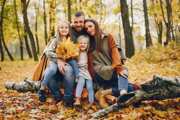 Famiglia con bambini carini in un parco in autunno