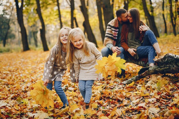 Famiglia con bambini carini in un parco in autunno