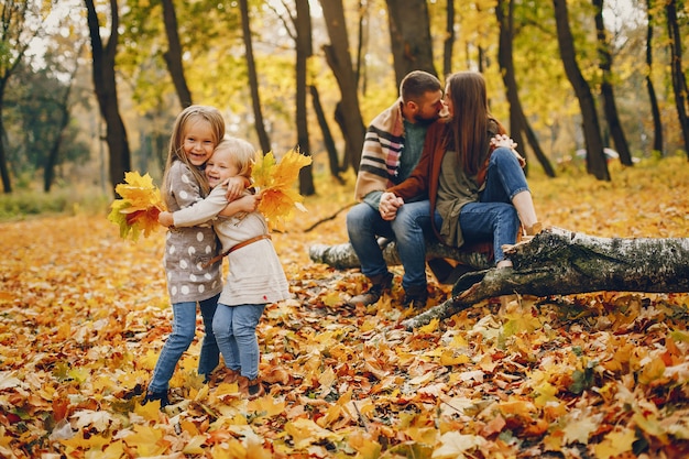 Famiglia con bambini carini in un parco in autunno