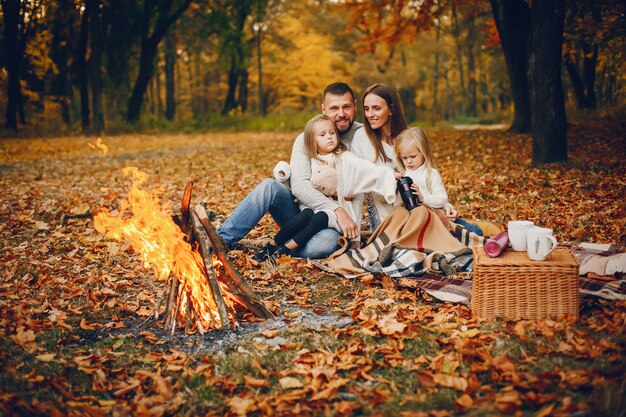 Famiglia con bambini carini in un parco in autunno