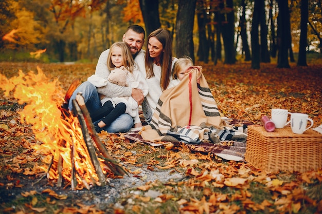 Famiglia con bambini carini in un parco in autunno