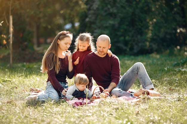 Famiglia con bambini carini in un parco in autunno